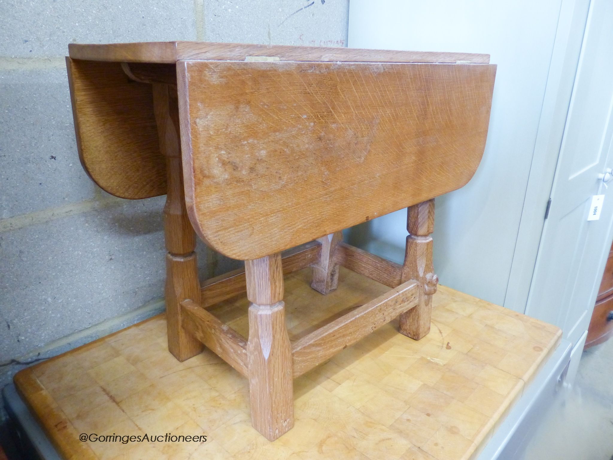 A small 'Beaverman' oak drop leaf occasional table with adzed top, 63cm extended, width 56cm, height 48cm.